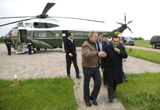 President George W. Bush escorts President Hosny Mubarak of Egypt after his arrival at the Bush Ranch in Crawford Texas Monday April 12 2004.    (UPI Photo\/White House\/Eric Draper)
