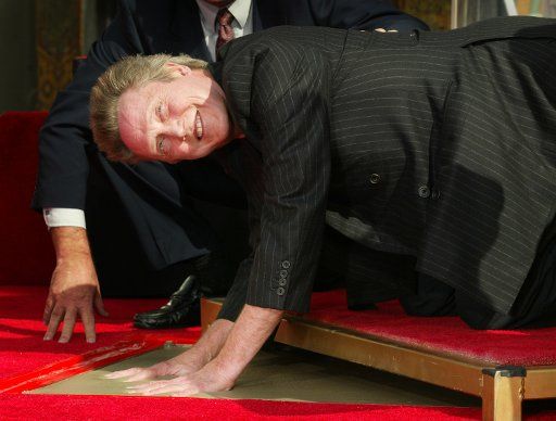 Academy Award winning actor Christopher Walken pushes his hands into the cement during the Legendary Hand & Footprints ceremony at Grauman\