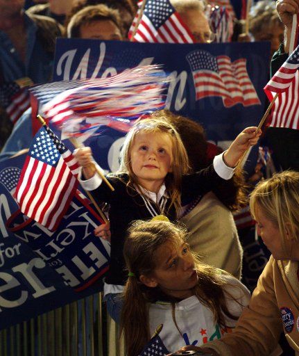A young girl waves the flag as John Kerry arrives in Dayton Ohio Oct. 192004.  Kerry spoke before a crowd of about 2500.  (UPI Photo\/Mike Williamson)