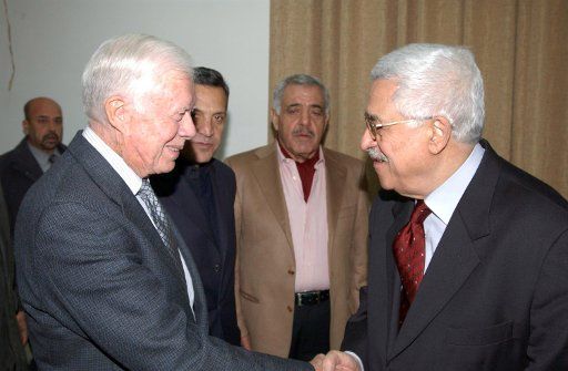 Former U.S. President Jimmy Carter (L) shakes hands with Palestinian presidential candidate Mahmoud Abbas at a meeting in the West Bank city of Ramallah on January 8 2005.  (UPI Photo\/Omar Rashidi)