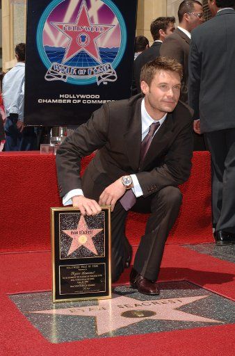 Broadcaster Ryan Seacrest host of the television show "American Idol" holds a replica plaque of his new star during an unveiling ceremony on the Hollywood Walk of Fame in Los Angeles April 20 2005. Seacrest was honored with the 2 282nd star for his...