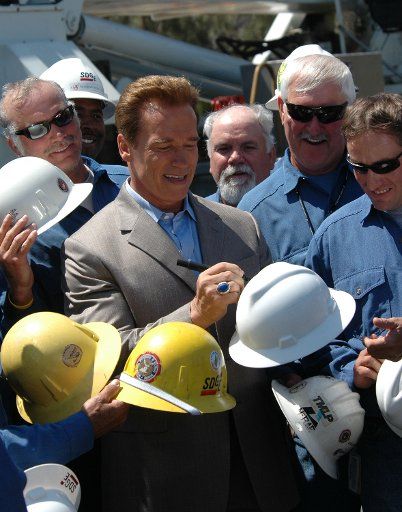 California governor Arnold Schwarzenegger autographs hardhats for employees of San Diego Gas & Electric Company July 7 2005 in San Diego California during dedication of the completion of new electrical power transmission lines....