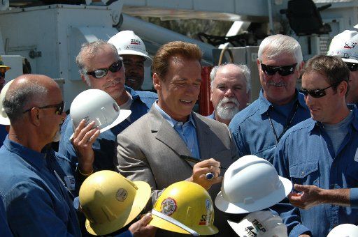 California governor Arnold Schwarzenegger autographs hardhats for employees of San Diego Gas & Electric Company July 7 2005 in San Diego California during dedication of the completion of new electrical power transmission lines.     ( UPI...
