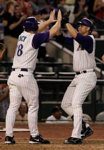 Arizona Diamondback Alex Cintron (R) is congratulated by Chad Tracy as Cintron crosses the plate with a two run homer off Philadelphia Phillies Jon Leiber August 27 2005 in Phoenix AZ.     (UPI Photo\/Will Powers)     