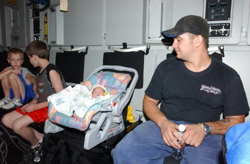 Senior Airman Aaron Post 81st Tansportation Squadron based at Keesler Air Force Base Mississippi is evacuted to Texas on August 30. 2005 with his newborn daughter born during Hurricane Katrina without any power in the hospital at Keesler. (UPI...