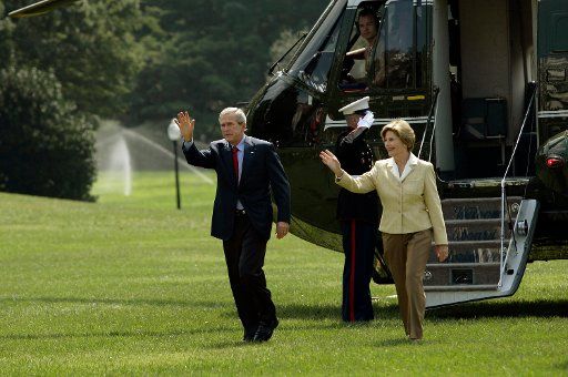 U.S. President George W. Bush and First Lady Laura return to the White House via Marine One landing on the south lawn after spending two days at Camp David on September 18 2005. The President and Mrs. Bush wave to visitors of the White House.  (UPI...