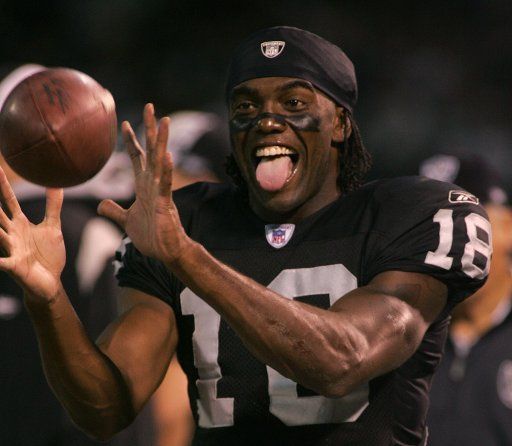 Oakland Raiders new wide receiver Randy Moss keeps warm on the sidelines while the defense plays against the Kansas City Chiefs  on September 18 2005 in Oakland CA.  (UPI Photo\/Terry Schmitt)