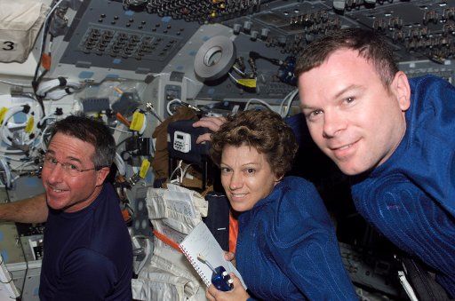 Eileen M. Collins STS-114 commander flanked by astronauts Stephen K. Robinson (left) mission specialist and James M. Kelly pilot are shown aboard the Space Shuttle Discovery on July 28 2005.  (UPI Photo\/NASA)