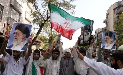 Iranian hardline students hold pictures of the supreme leader Ayatollah Ali Khamenei in front of the British Embassy in TehranAugust 14 2005.(UPI photo\/Mohammad Kheirkhah)
