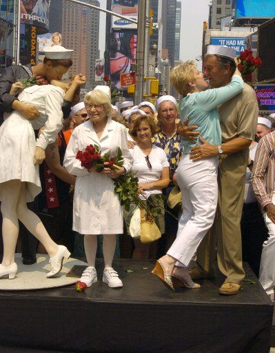 Edith Shain and Carl Muscarello who gets a kiss from wife Shelly are shown next to the Unconditional Surrender Sculpture at the 60th Anniversary of the end of World War II in Times Square on August 14 2005.  They were recreating the famous pose from...