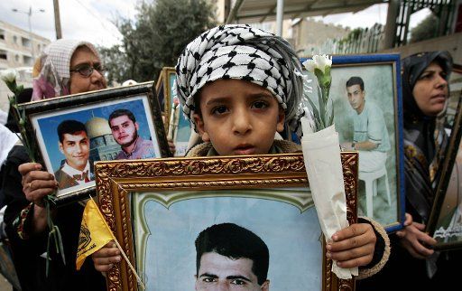 Palestinian women and children hold up pictures of their jailed relatives during a protest calling for their release in Gaza City on October 31 2005.   (UPI Photo\/Ismael Mohamad )