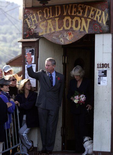 Prince Charles (L) waves to the crowd and his wife Camilla Duchess of Cornwall looks down towards "Fred" the dog after walking out of the Old Western Saloon at Point Reyes Station CA on  November 5 2005.  (UPI Photo\/Fred Larson\/Pool)