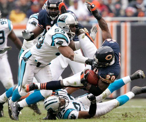 Chicago Bears running back Thomas Jones (20) is tackled by Carolina Panthers\