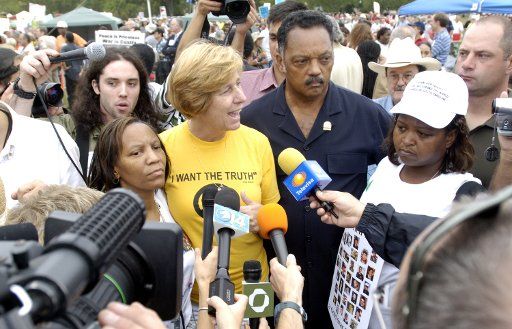 Anti-War activist Cindy Sheehan (C) and civil rights leader Reverend Jesse Jackson (R) answer questions from the media during an anti-war rally in Washington on Sept. 24 2005. Thousands of anti-war demonstrators rallied outside the White House...