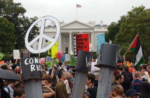 Demonstrators carry peace and other signs as they march past the White House in a massive anti-war protest in downtown Washington on September 24 2005.  Tens of thousands of diverse demonstrators protested the Iraq War.   (UPI Photo\/Pat Benic)