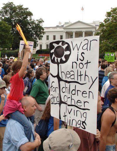 Demonstrators of all ages carry signs as they march past the White House in a massive anti-war protest in downtown Washington on September 24 2005.  Tens of thousands of diverse demonstrators protested the Iraq War.   (UPI Photo\/Pat Benic)