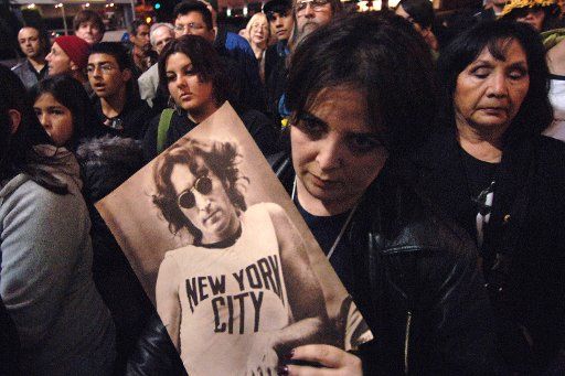 Eren Roussak holds a picture of John Lennon at a candle light vigil in honor of the 25th anniversary of  Lennon\