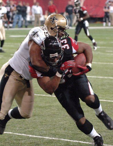 Atlanta Falcons fullback Justin Griffith (33) gets eight yards and a first down on a first quarter pass reception before New Orleans Saints cornerback Ronald McKinnin (59) shoves him out of bounds December 12 2005 in AtlantaÕs Georgia Dome. The...