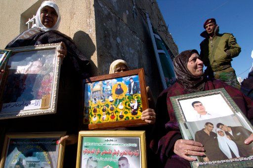 Palestinians demonstrate for the release of prisoners outside the  inaugural session of the Palestinian Parliament which is dominated by Hamas in Ramallah West Bank February 18 2006. Palestinian leader Mahmud Abbas urged the new Parliament to...