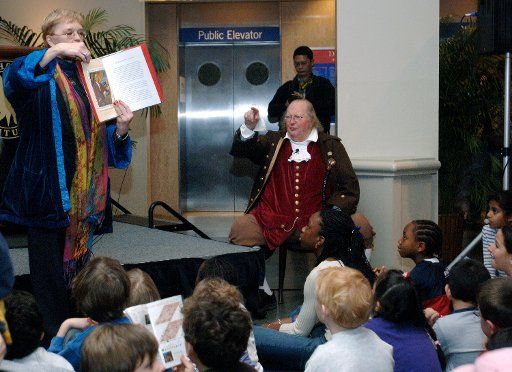 Author Cheryl Harness and Benjamin Franklin portrayer Ralph Archbold speak to a group of children about Franklin\