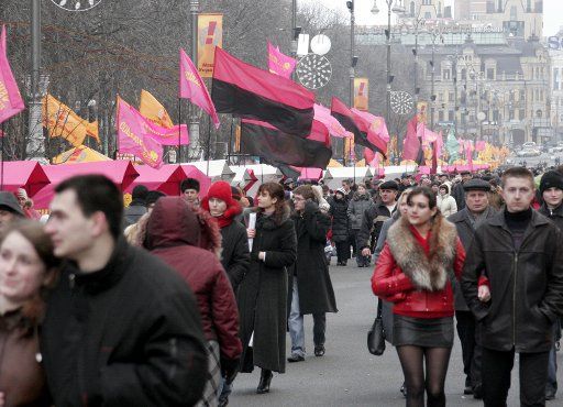 Pedestrians walk on central street Kreshchatik in Kiev decorated by pink flags of the Ukraine\