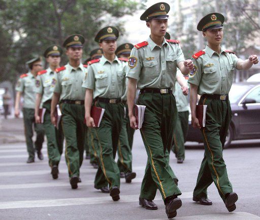 Chinese People Liberation Army (PLA) soldiers march with their books through the diplomatic area of Beijing China on May 26 2006.  China plans to accelerate efforts to modernize its  army state media reported. (UPI Photo\/Stephen Shaver)