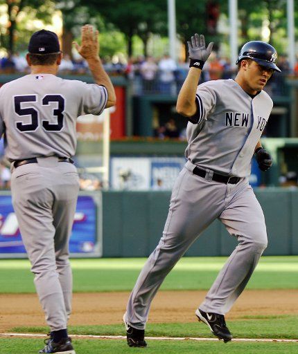 The New York Yankees Andy Phillips (12) is congratulated by third base coach seventh inning against Sendy Rleal of the Baltimore Orioles at Orioles Park at Camden Yards in Baltimore MD on June 3 2006.  The Yankees defeated the Orioles 6-5 in ten...