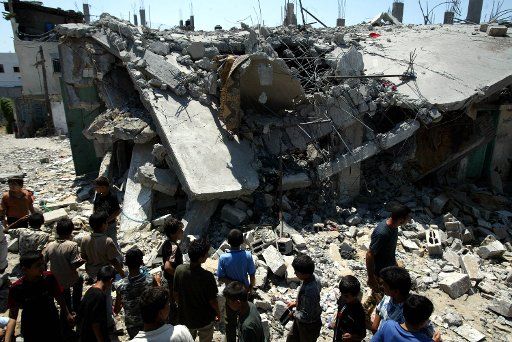 Palestinians gather at the site of an Israeli missile strike in the Jebaliya refugee camp north of Gaza City late August 14 2006. The strike completely destroyed a building wounding 14 in the attack hospital officials said witnesses said.   (UPI...