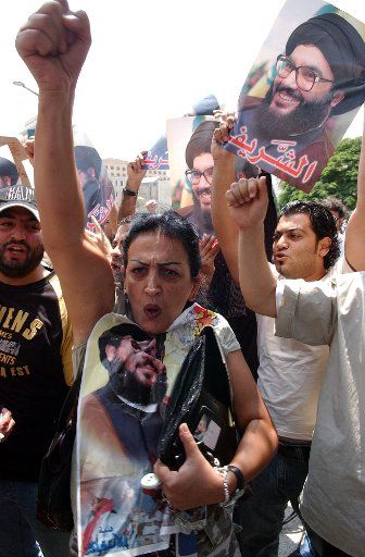 Demonstrators hold posters of Hezbollah leader Hassan Nasrallah while they attack the United Nations headquarters in Beirut on Sunday July 30 2006 after Israeli jet struck a building in the south Lebanon town of Qana killing over 50 civilians. Thus...
