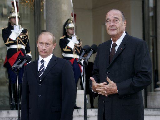 French President Jacques Chirac (R) and Russian President Vladimir Putin listen to a journalist\