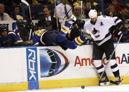 St. Louis Blues Petr Cajanek (L) is checked into his bench by Vancouver Canucks Trevor Linden during the first period at the Scouttrade Center in St. Louis on October 20 2006. (UPI Photo\/Bill Greenblatt)