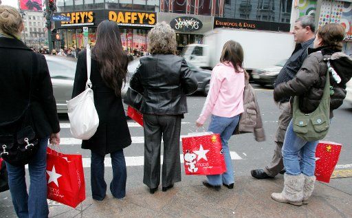 Shoppers wait to cross the street in Herald Square near Macy\