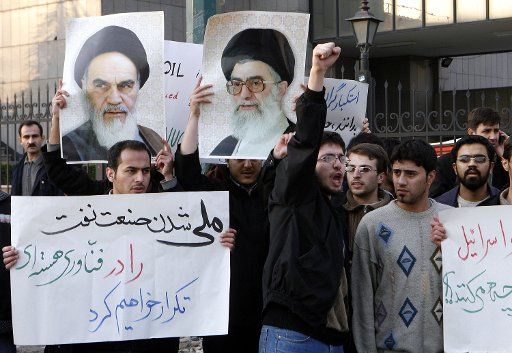 Iranian students hold a portrait of Iran\