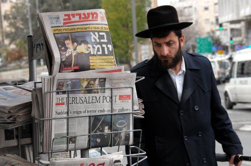 An Orthodox Jew walks by Israeli newspapers in downtown Jerusalem announcing the execution of former Iraqi President Saddam Hussein December 31 2006.  (UPI Photo\/Debbie Hilll)