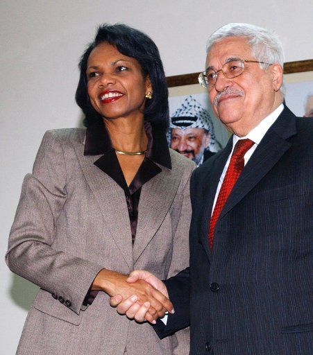 U.S. Secretary of State Condoleezza Rice (L) and Palestinian President Mahmoud Abbas shake hands during a meeting at his office in Ramallah on the West Bank on January 14 2007.  In the background is a picture of former Palestinian leader Yasser...