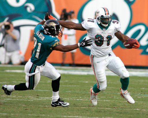 Miami Dolphins running back Sammy Morris runs out of the grasp of Jacksonville Jaguars conerback Terry Cousin in first half NFL action at Dolphin Stadium in Miami on December 3 2006.  (UPI Photo\/Michael Bush)