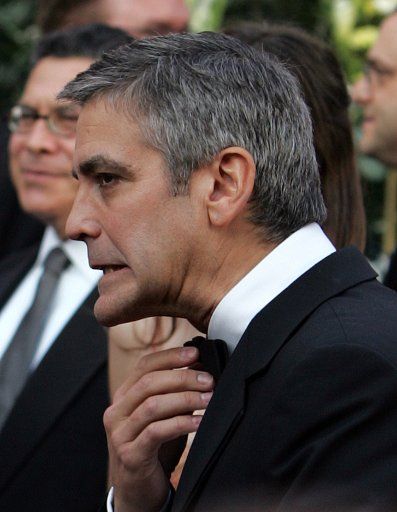 Actor George Clooney adjusts his tie as he arrives for the 78th Annual Academy Awards at the Kodak Theatre in Hollywood Ca. on March 5 2006.   (UPI Photo\/Terry Schmitt)