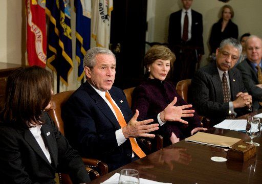 First Lady Laura Bush (C) listens as U.S. President George W Bush speaks during a meeting on volunteerism in the Roosevelt Room of the White House on February 13 2007.    (UPI Photo\/Brendan Smialowski\/POOL)