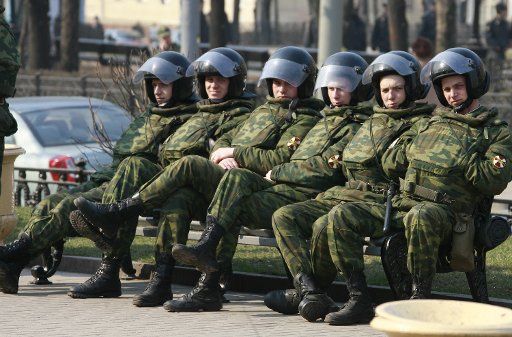 A riot police rest in the warm spring sunshine as they monitor a rally denouncing social inequality in central Moscow on March 31 2007.  Several political parties and groups took to the streets in Moscow on Saturday during the \