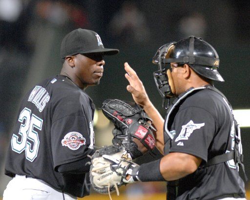 Florida Marlins pitcher Dontrelle Willis (L) and catcher Miguel Olivo have a quick meeting on the mound to discuss Atlanta Braves hitter Chipper Jones in the third inning at Turner Field in Atlanta April 13 2007. The Marlins defeated the Braves 11-4....