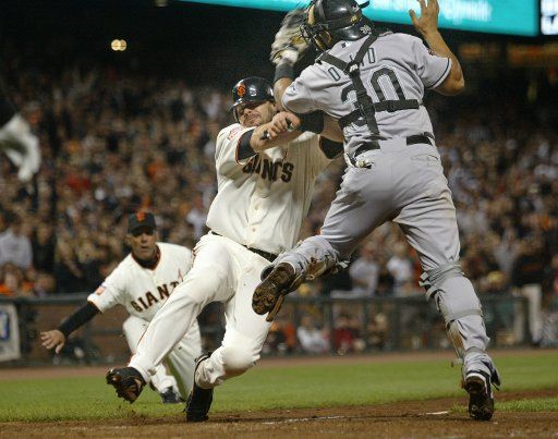 San Francisco Giants Ryan Klesko (C) collides with Florida Marlins catcher Miguel Olivo in the fifth inning at AT&T Park in San Francisco on July 27 2007. Third base coach Tim Flannery makes the safe call in the background. (UPI Photo\/Bruce Gordon)