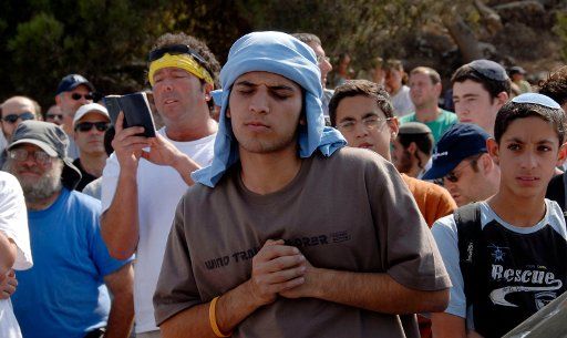 Israeli right-wing settlers pray in the Jewish settlement Efrat in the West Bank September 30 2007 before marching to Givat Ha\