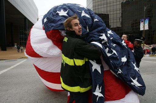 St. Louis fire captain Kurt Bruekmann looks for help as firefighters attempt to raise an American Flag during stiff winds before the Thanksgiving Day Parade in St. Louis on November 22 2007. (UPI Photo\/Bill Greenblatt)