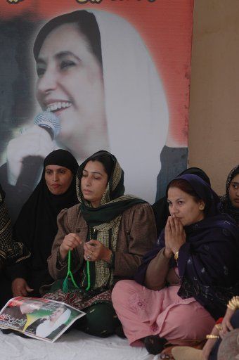 Supporters of slain Pakistani opposition leader Benazir Bhutto pray during a protest near the spot where she was killed in Rawalpindi Pakistan on January 3 2008. (UPI Photo\/Suhail Kureishi).