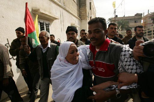 Freed Palestinian prisoner Khalid Baraka (L) age 24 is embraced by a relative after arriving at his home having served 4 years of an 11 year sentence in an Israeli prison in Deir El-Balah Gaza on December 3 2007. Israel released 429 ...