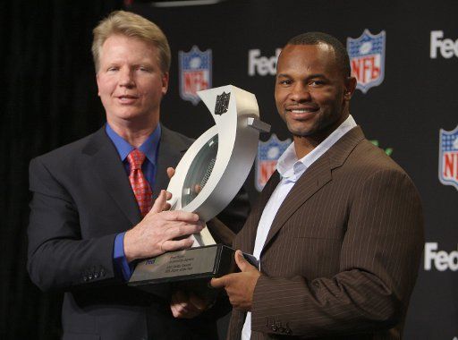 Former QB and current broadcaster Phil Simms (L) awards the FedEx Ground NFL Player of the Year trophy to Jacksonville Jaguars Fred Taylor at the Phoenix Convention Center in Phoenix Arizona on January 30 2008. (UPI Photo\/Terry Schmitt)