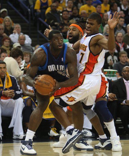 Dallas Mavericks Brandon Bass (L) looks to the basket while guarded by Golden State Warriors Baron Davis (C) and Kelenna Azubuike (7) at the Oracle Arena in Oakland California on March 30 2008. (UPI Photo\/Terry Schmitt)