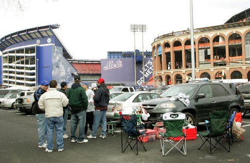 People tailgate in the parking lot as Shea stadium left and the new Citi Field ball park is seen in the background as the New York Mets host their last home opener at Shea on April 8 2008 in New York. The new ballpark Citi Field is being ...