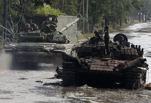 Russian soldiers roll past destroyed a Georgian tank in the South Ossetian capital of Tskhinvali on August 11 2008. (UPI Photo\/Anatoli Ivanov)