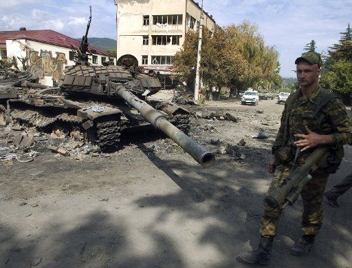 Russian soldier passes a destroyed Georgian tank in the South Ossetian capital of Tskhinvali on August 11 2008. (UPI Photo\/Anatoli Ivanov)